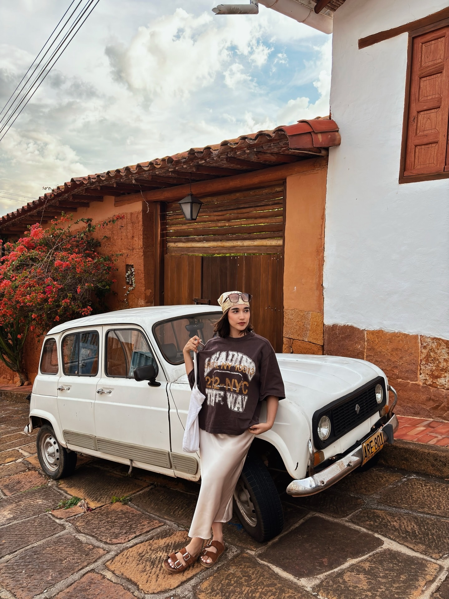 Paula en Barichara con falda, junto a un carro blanco